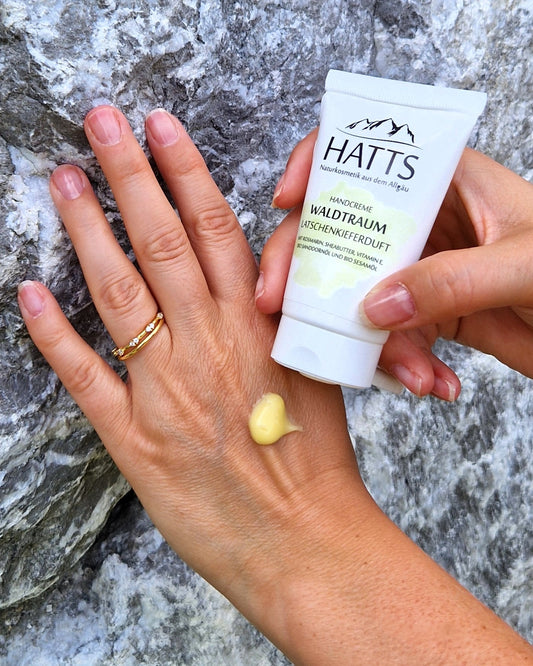 Frau trägt HATTS Naturkosmetik Handcreme Latschenkiefer auf – vegane Handpflege mit Sheabutter und Bio-Ölen.
