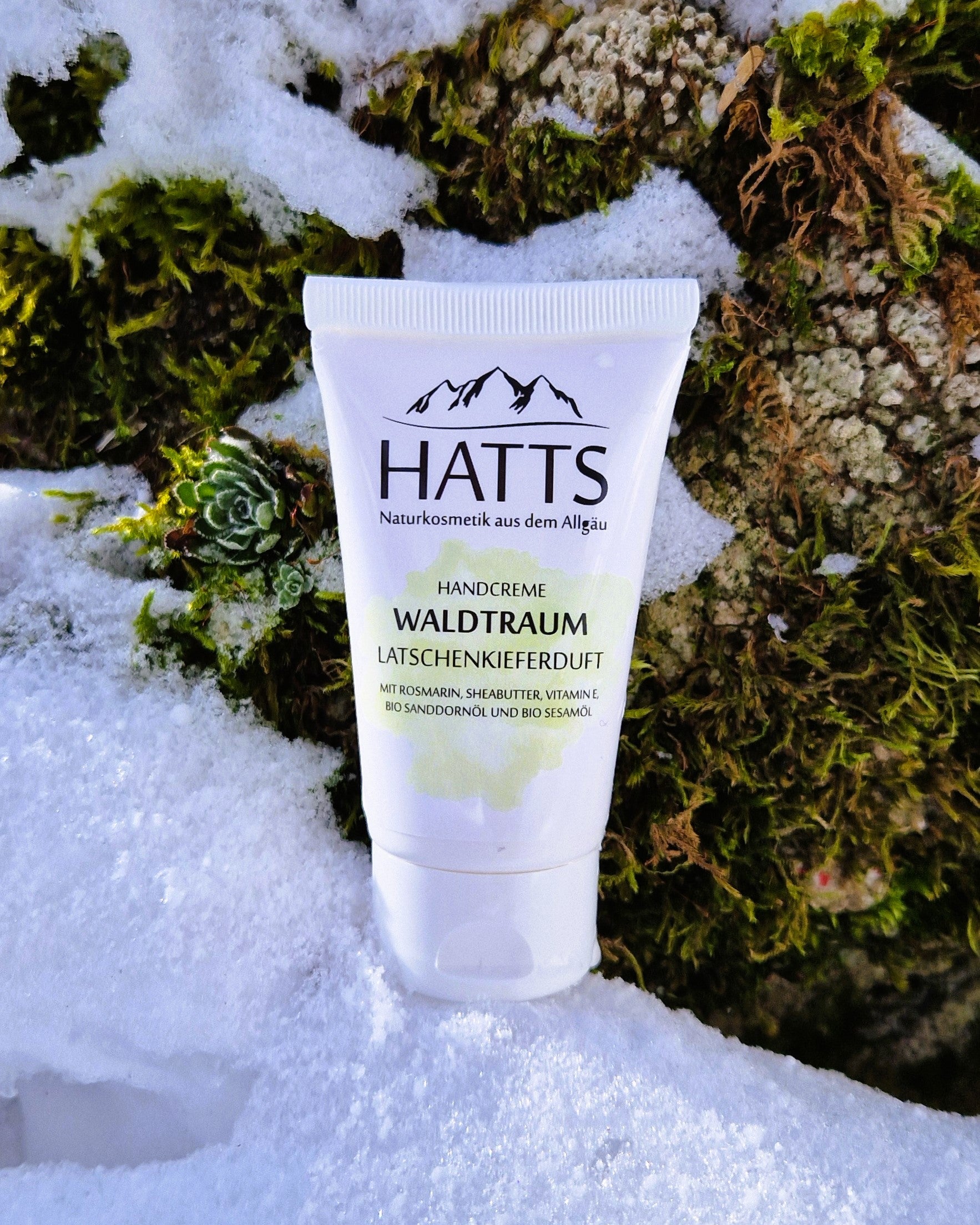 HATTS Handcreme Waldtraum vor Naturkulisse mit Moos, Stein und Schnee – vegane Naturkosmetik.